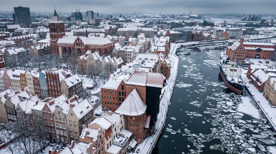 Zaśnieżone dachy Głównego Miasta i Żuraw nad Motławą w Gdańsku - widok z drona