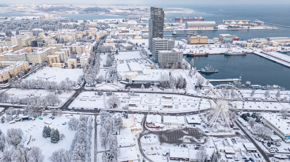 Zaśnieżone dachy śródmieścia Gdyni i Sea Towers nad zimowym morzem - widok z drona